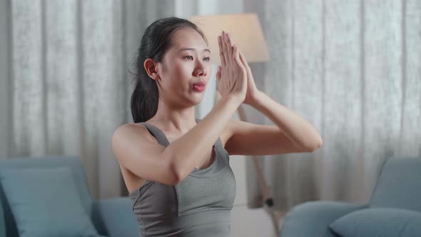 Young Asian Athletic Female Exercising, Stretching And Practicing Yoga On The Mat At Home