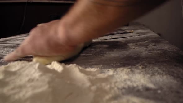 Men's hands hold dough. making raw dough for pizza, rolls or bread.