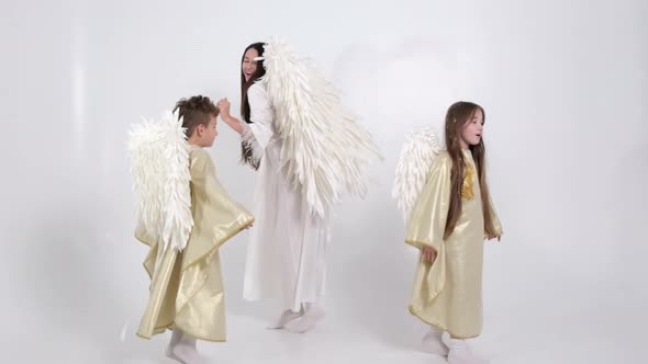 Family Dancing with Angel Wings on a White Background in Smoke