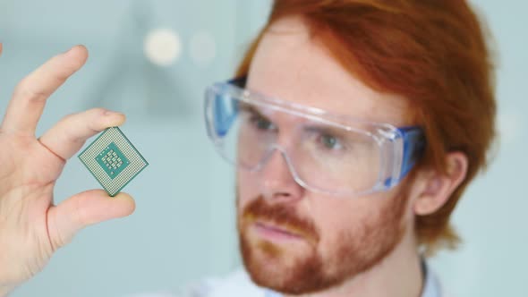 Man in Protective Glasses Looking at Computer Chip