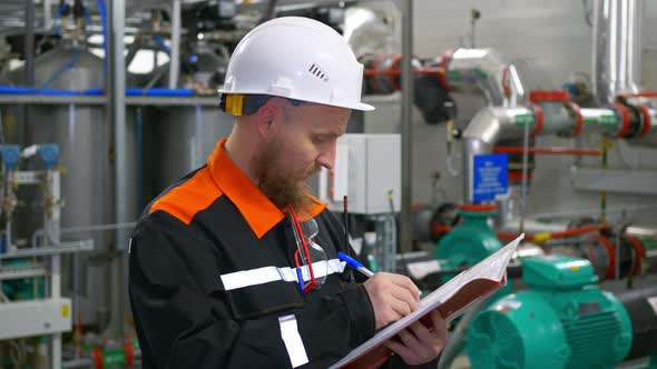 The Chief Engineer of Industrial Production Stands in the Workshop of the Pumping Station Inspecting