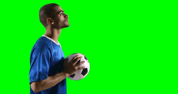 Profile of football player holding a football