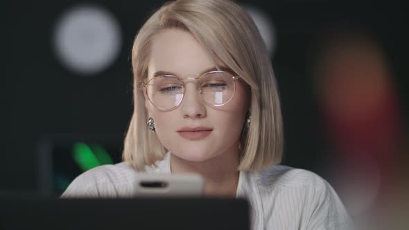 Beautiful Business Woman Using Mobile Phone in Night Office.