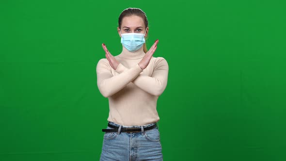 Middle Shot Portrait of Serious Caucasian Woman in Covid Face Mask Crossing Hands No Gesture 