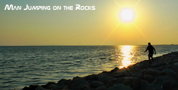 Man Jumping on the Rocks near the Seaside