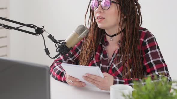 Podcasting and Radio Concept. Radio Host Young Woman in the Studio in Front of a Microphone