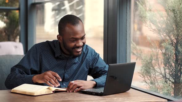 Businessman Working Remotely with Laptop at Cafe