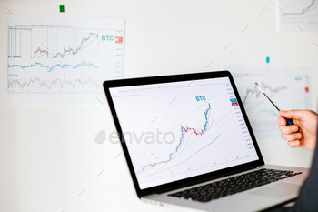 estment broker trading bitcoin crypto currency using phone and laptop.