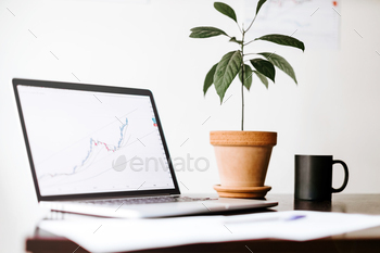 . Investment manager desk with with green plant and cup of coffee
