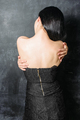 woman in dress standing with back on black stone wall background - PhotoDune Item for Sale