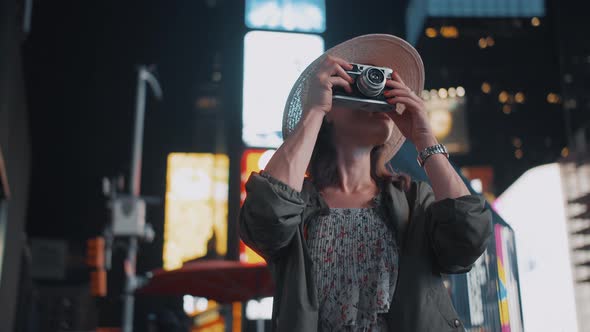 Smiling girl with a retro camera in Times Square