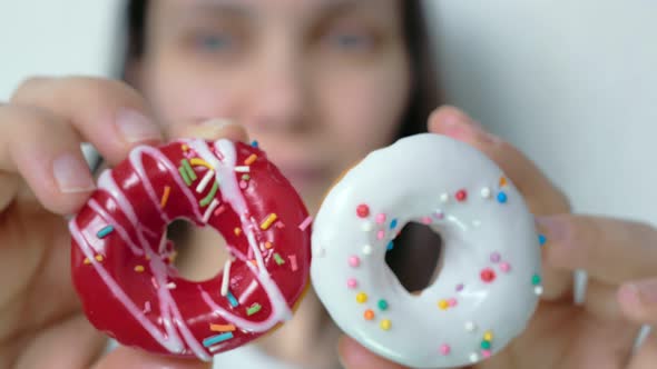 In Two Hands a Closeup Woman Shows Two Donuts