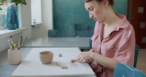 Female Potter Sitting and Makes a Cup at the Table. Woman Making Ceramic Item. Pottery Working