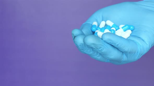 Close Up of Man Hand in Protective Gloves Holding Capsules 