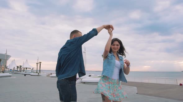 Beautiful Sweet Couple Riding on Roller Skates Quads Holding Hands Near the Sea Slow Motion