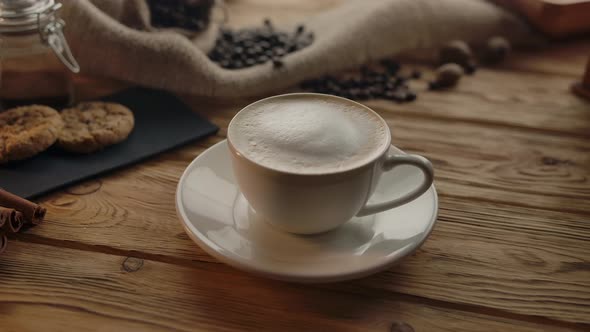 The Camera Revolves Around a Cup of Coffee Taken By an Unrecognizable Woman