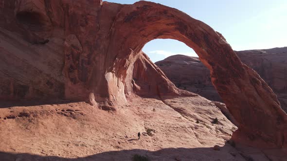 Aerial of a hiker under the Corona Arch near Moab, Utah