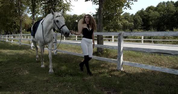 Young Jockey Walks With A Horse In An Open-air Cage On The Nature