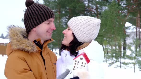 Man and woman in love outdoor date in winter with symbol of home and love