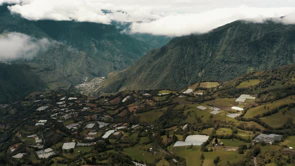 Andes Farmland And Town Of Baños de Agua Santa Near Tungurahua Volcano In Ecuador. Aerial Tilt-up Sh