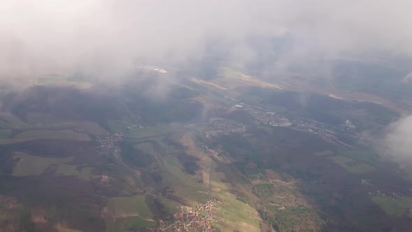 Flying in a Plane in the Middle of the Clouds the Landscape is Visible