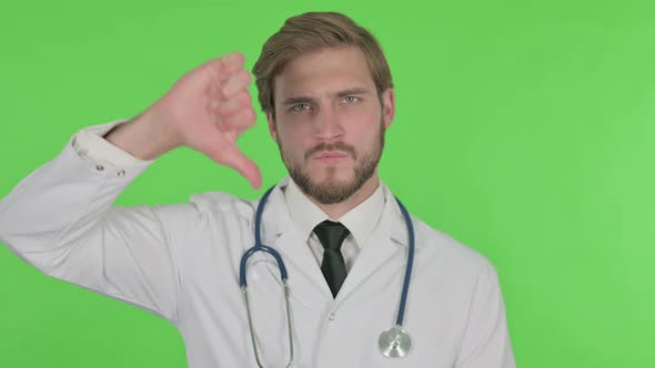 Thumbs Down By Young Doctor on Green Background