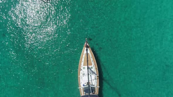 Aerial view above of single sailboat anchored in the mediterranean sea, Greece.