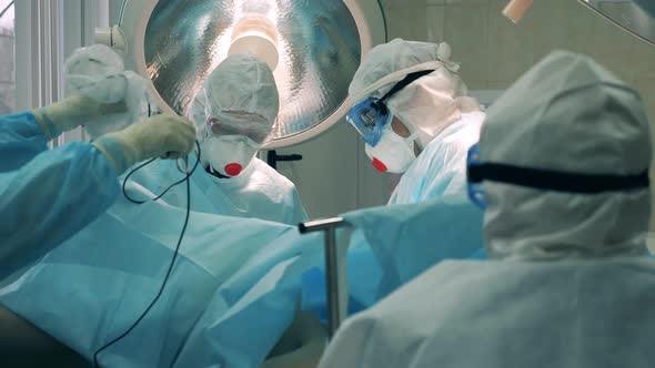 Surgeons in Safety Wear Are Treating a Patient