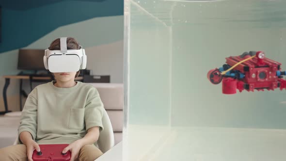 Schoolboy Wearing VR Glasses Controlling Robo Boat