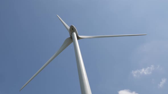 Wind turbine in operation on a sunny blue sky. 4K video