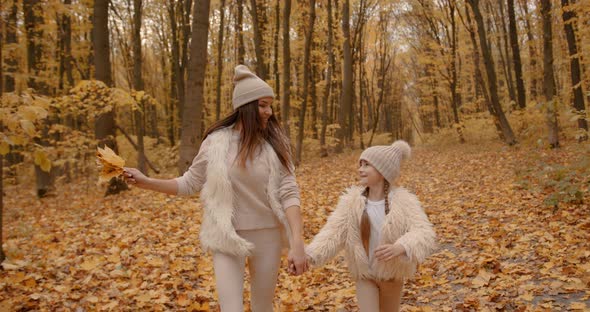 Mother Walking with Preteen Daughter in Autumn Park