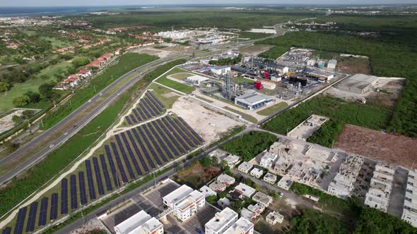 Aerial Flying Over Residencial SeleneV Development Next To CEPM Energy Plant With Rows Of Solar Pane