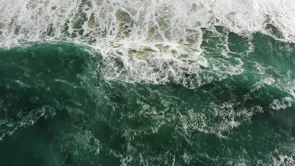 Upper View of Ocean Surf Washing Sand Beach with Dense Foam