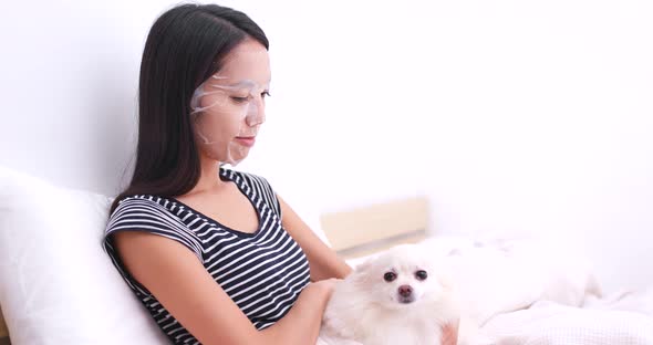 Woman apply paper mask and touch on her dog