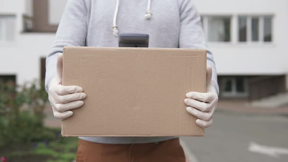 Parcel delivery during a pandemic. Payment via POS-wireless terminal with a card or smartphone