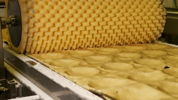 Dough with sugar at the conveyor belt of a bakery factory