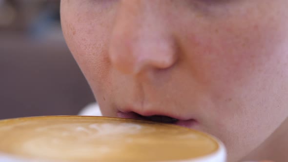 Close Up of Female Mouth Drinking Vegan Coffee Latte Carefully