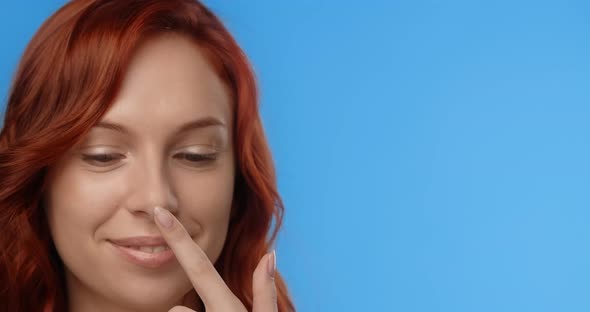 Redhead Woman Puts Drop of Face Cream to the Tip of Her Nose and Laughs