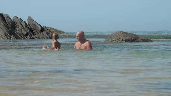 Happy Man Spends Time with Little Son in Azure Sea Bay