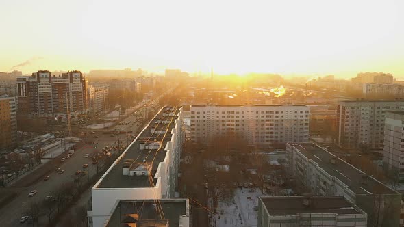 An Aerial View of the Winter City. Homes and Moving Cars in the Bright Sun