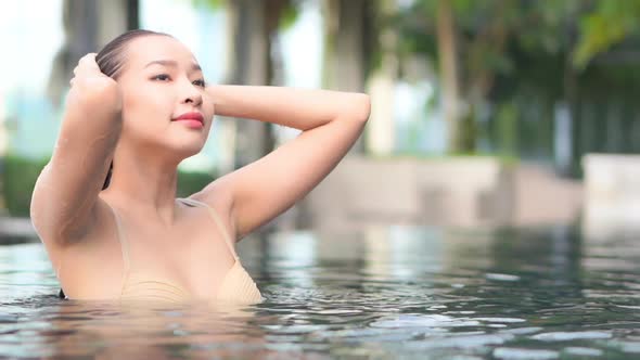 Young asian woman enjoy around outdoor swimming pool for leisure