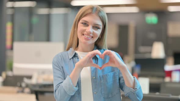 Young Woman Showing Heart Sign By Hand