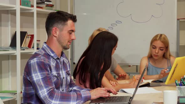 Handsome Male Student Showing Thumbs Up While Using Laptop