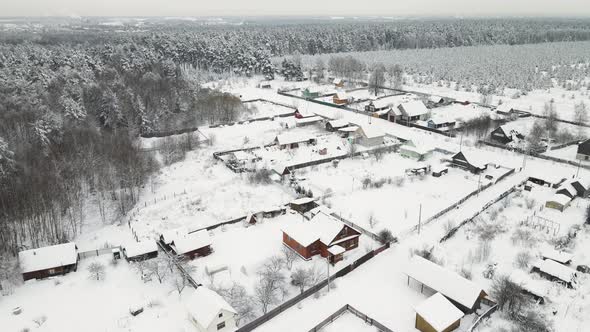 Snowcovered Village on the Edge of a Coniferous Forest Aerial View