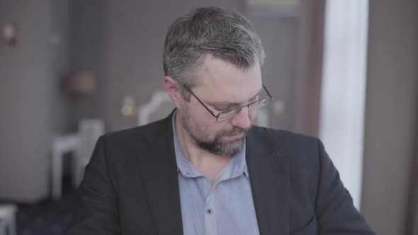 Close-up of Elegant Senior Businessman Posing in Hotel Room. Portrait of Confident Caucasian Grey