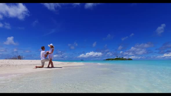 Man and woman relax on idyllic tourist beach trip by blue ocean with white sand background of the Ma