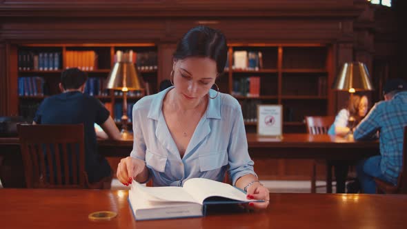 Young girl reading a book in the library, NYC