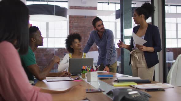 Mixed race business colleagues sitting having a discussion in meeting room