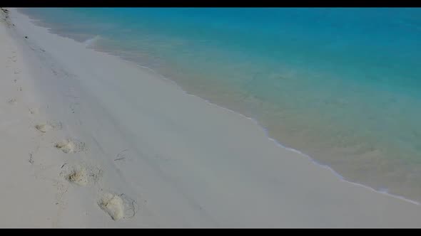 Aerial drone shot tourism of perfect tourist beach trip by clear ocean with white sandy background o