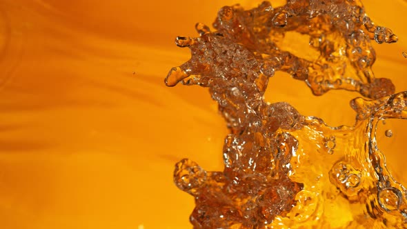 Super Slow Motion Shot of Splashing Golden Liquid at 1000 Fps